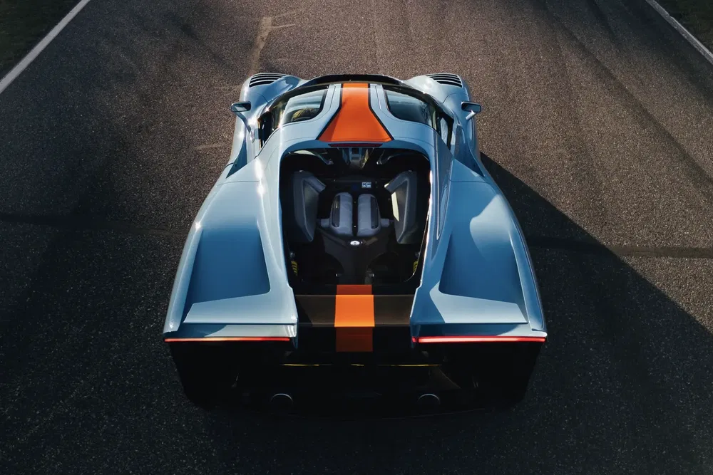 {"fr":"Voiture de sport McLaren Solus GT vue arrière sur piste avec livrée bleue et orange.","nl":"Achteraanzicht van McLaren Solus GT sportwagen op het circuit met blauwe en oranje livery."}