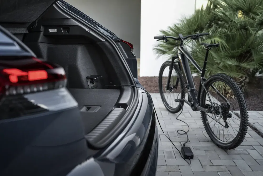 Coffre ouvert de Volkswagen ID.5 avec vélo électrique connecté à une prise de charge.