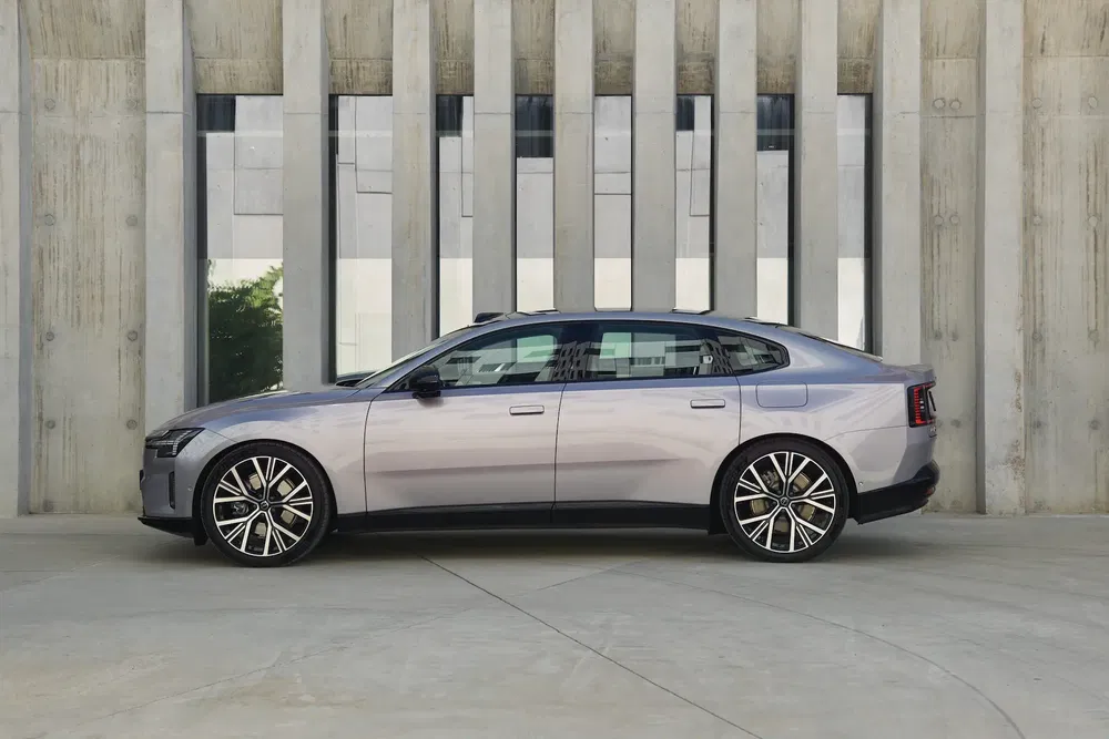 Vue latérale de la voiture électrique Polestar 2, stationnée devant un mur moderne.