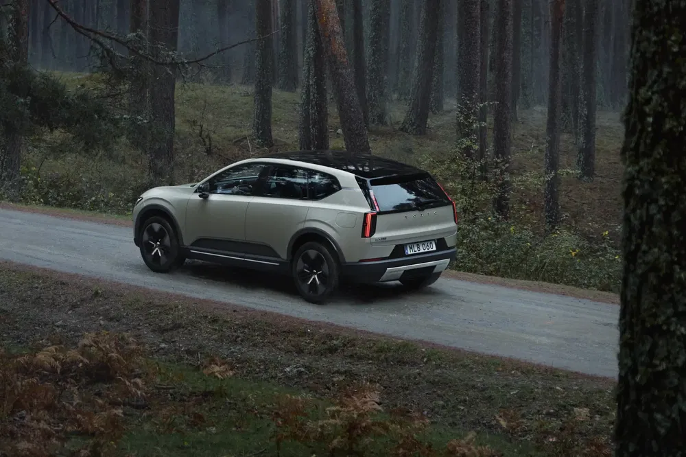 SUV moderne dans une forêt, Kia EV9 circulant sur un chemin de terre.
