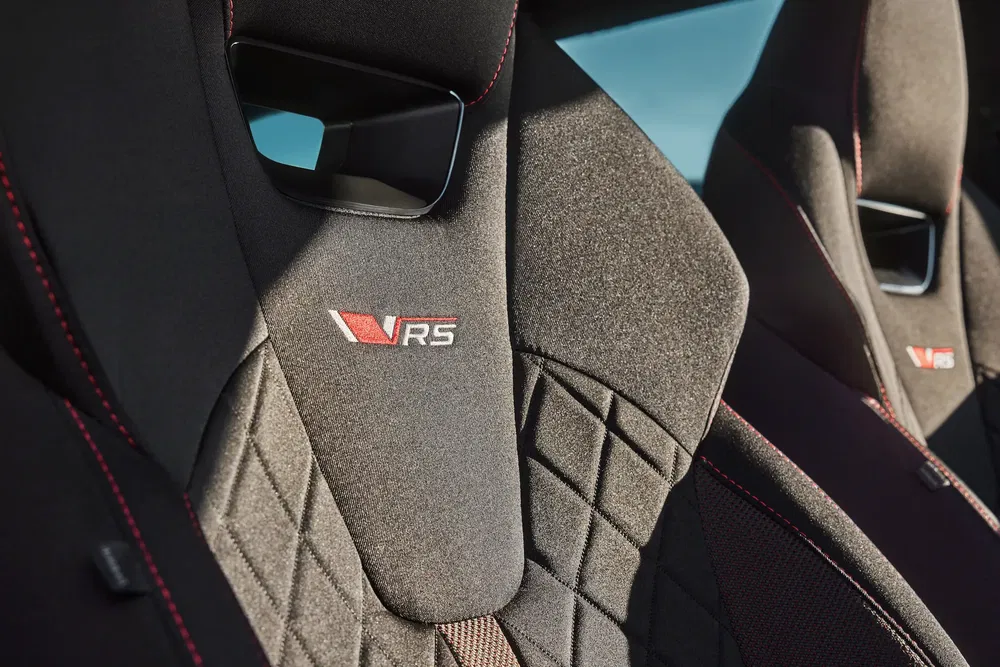 Sièges sport brodés VRS avec surpiqûres rouges dans une voiture de performance.