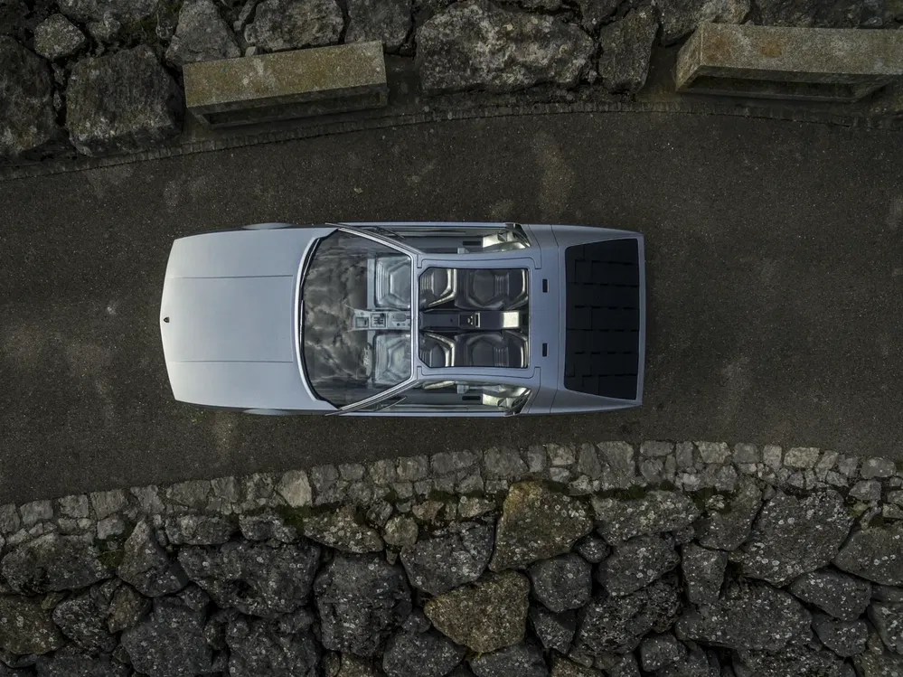 Luchtfoto van een BMW Vision Neue Klasse op kasseien, futuristisch interieur zichtbaar.