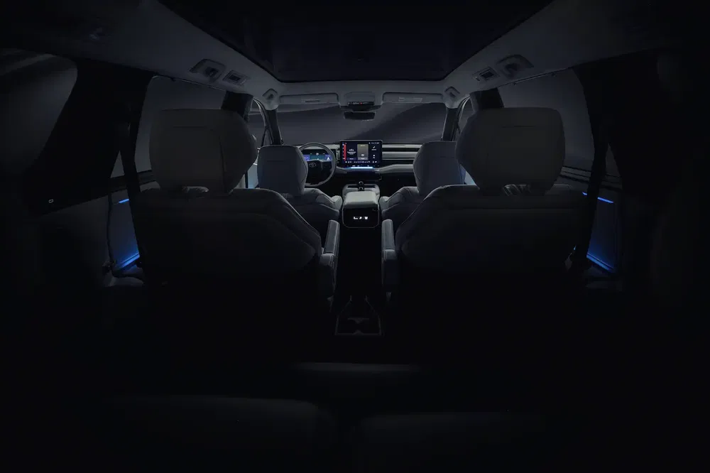 Intérieur spacieux et éclairé d'un véhicule moderne avec un tableau de bord numérique.