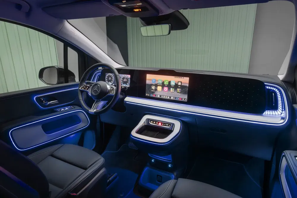 Intérieur d'un Mercedes électrique moderne avec éclairage LED et tableau de bord numérique.