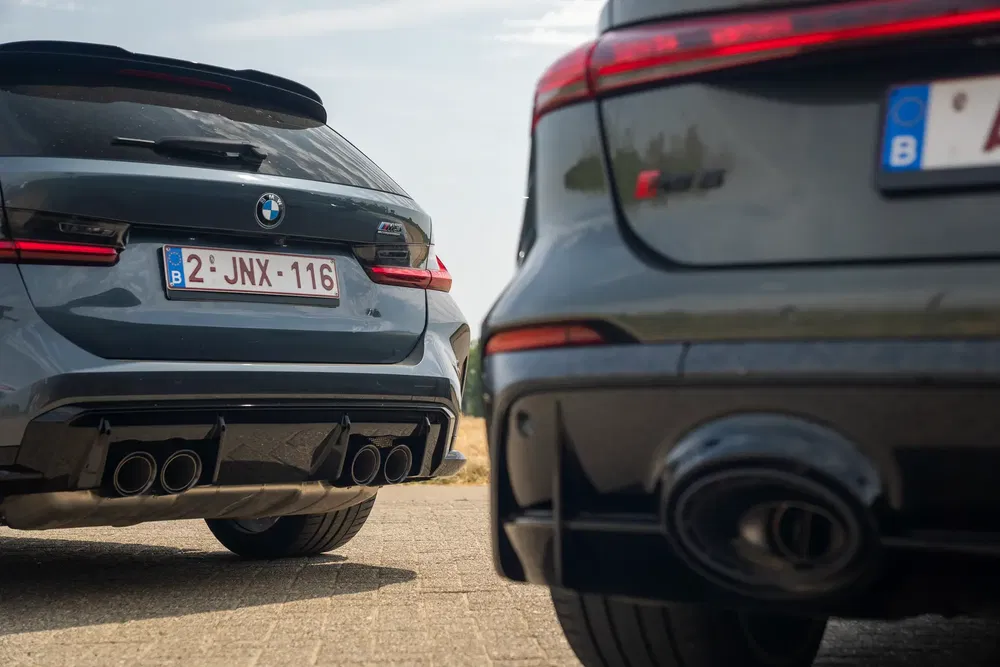 Achteraanzicht van BMW M3 Touring en Audi RS6 met kenmerkende uitlaatsystemen.