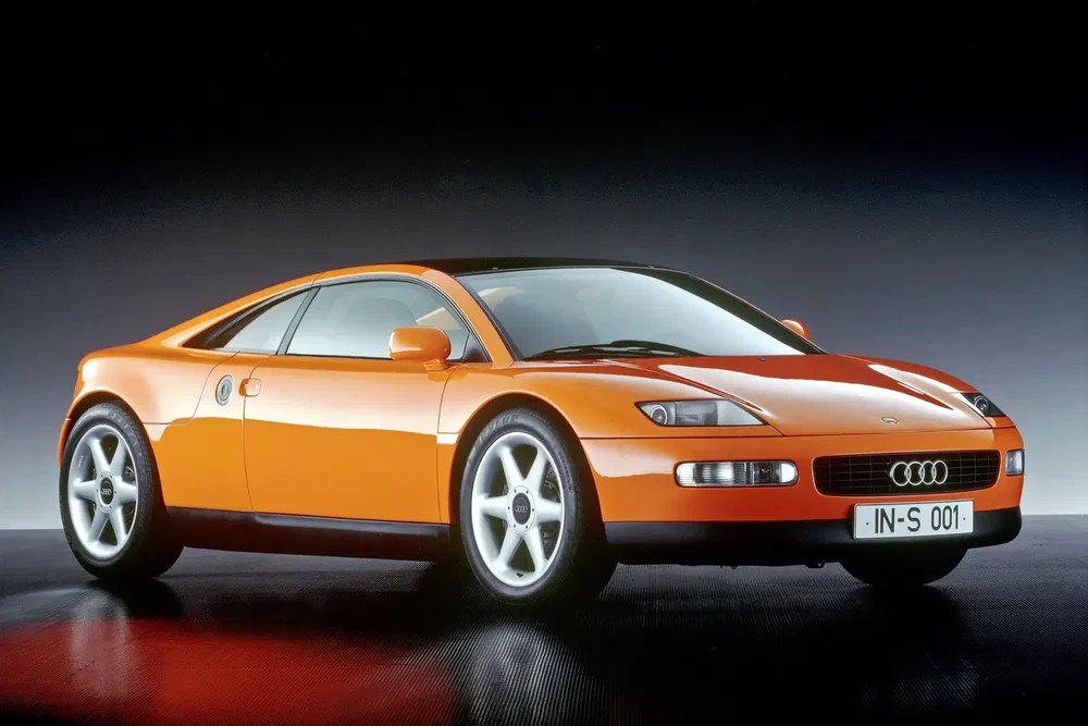Oranje Audi Quattro Spyder conceptauto met sportief ontwerp op een zwarte achtergrond.