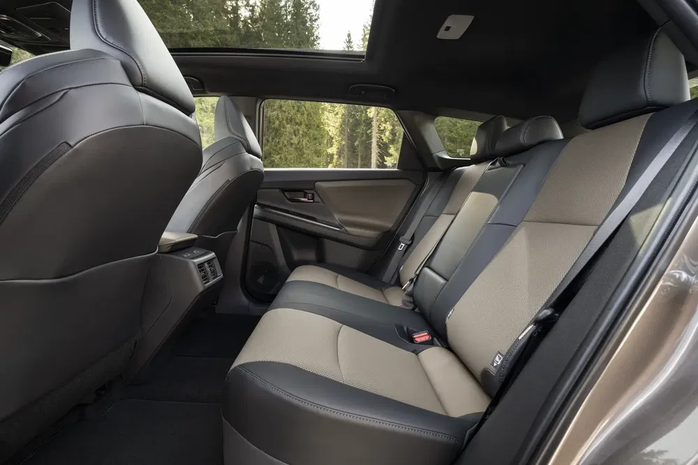 Intérieur spacieux de la Toyota RAV4 avec sièges arrière bicolores, foret en arrière-plan.