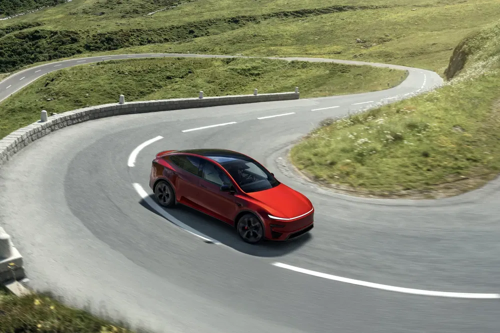 Rode elektrische auto nemen van een bocht op een kronkelige bergweg.