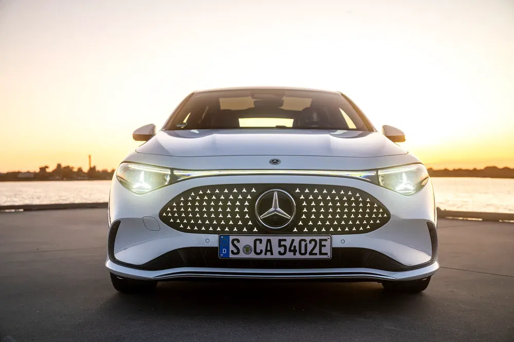 Vooraanzicht van de elektrische Mercedes-Benz bij zonsondergang aan het water.