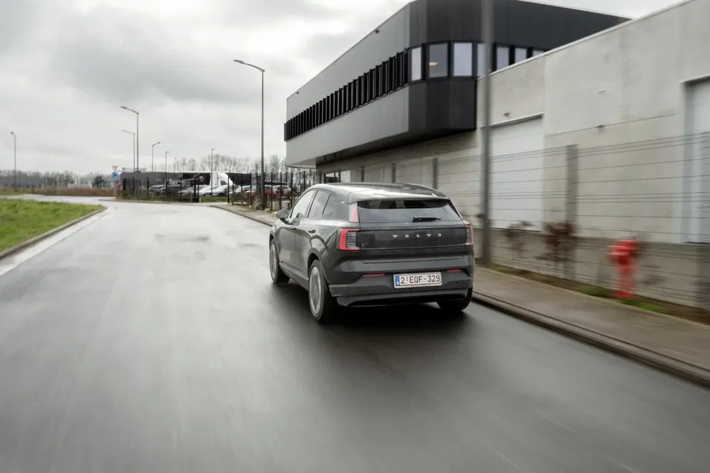 {"fr":"Voiture Polestar 2 grise sur route humide près de bâtiments industriels, temps nuageux.","nl":"Grijze Polestar 2 auto op natte weg bij industriële gebouwen, bewolkt weer."}