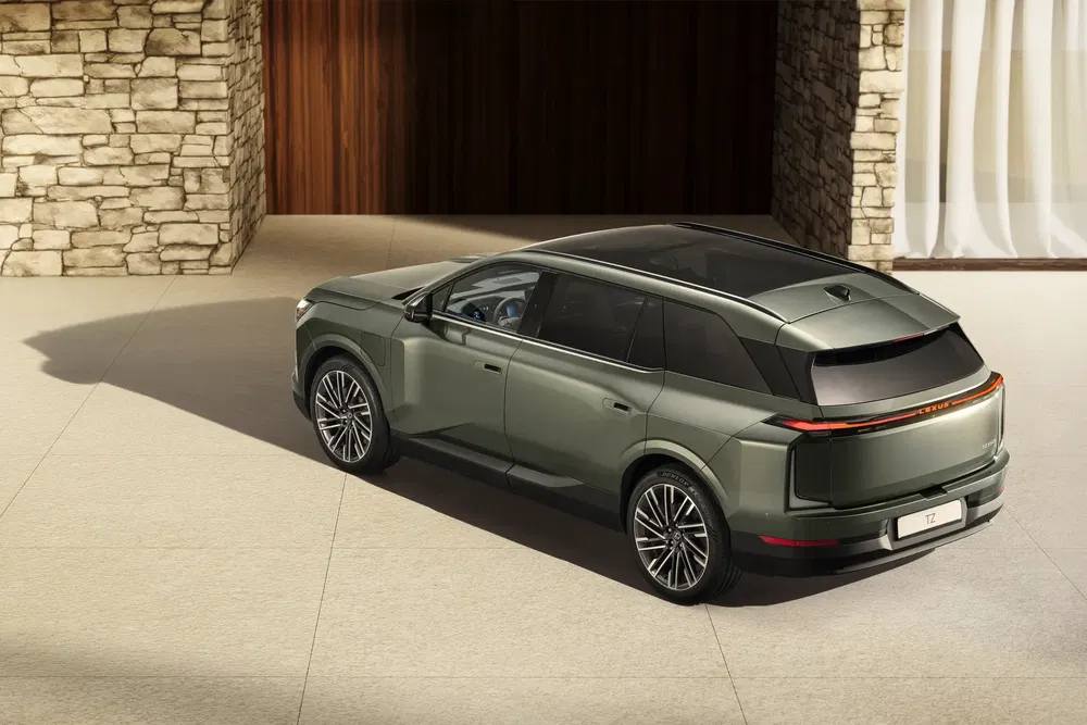 SUV électrique T7 moderne, stationné sur une allée pavée devant maison en pierre.