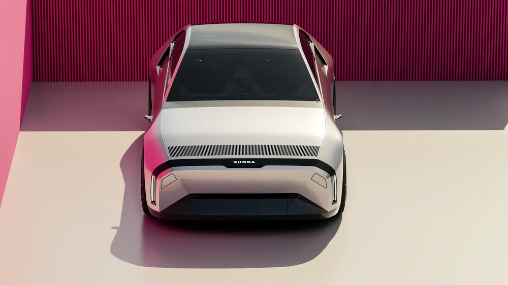 Futuristische Skoda conceptauto geparkeerd voor een levendige rode muur.
