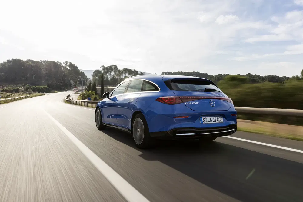 Mercedes-Benz CLA bleue sur route sinueuse en pleine nature.