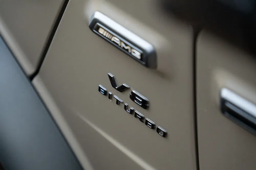 Badge AMG V8 Biturbo sur une Mercedes, emblème de performance et puissance de moteur.