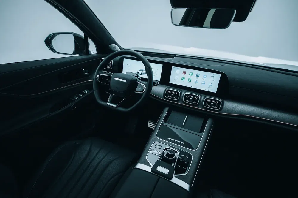 Intérieur moderne d'une voiture avec tableau de bord numérique et volant élégant.