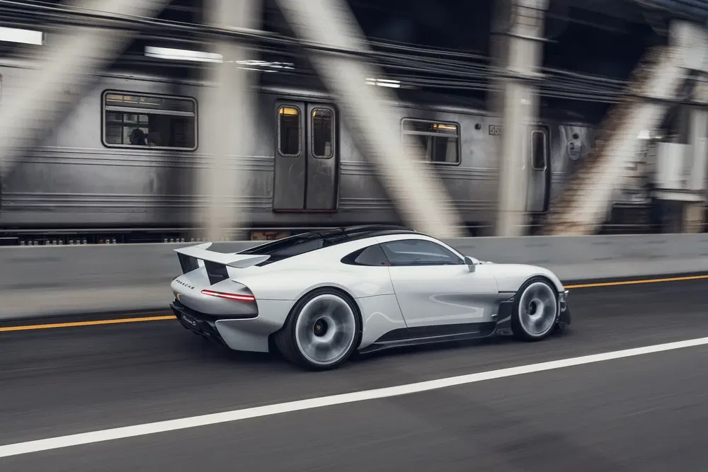 Mercedes EQXX concept op de weg, met een trein op de achtergrond.