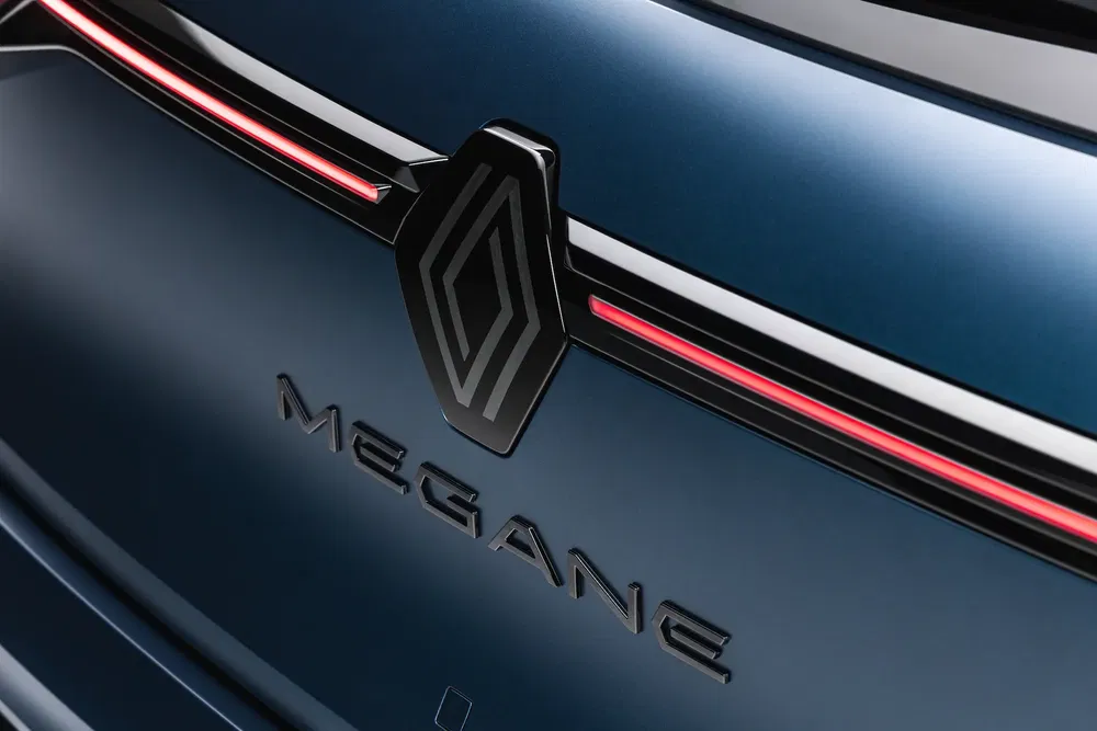 Logo Renault et badge Mégane sur hayon bleu foncé avec feux arrière élégants.