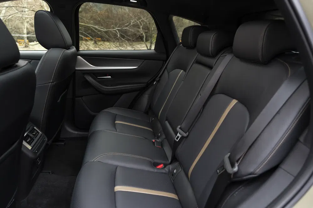 Intérieur luxueux d'une voiture avec sièges en cuir noir et surpiqûres contrastées.