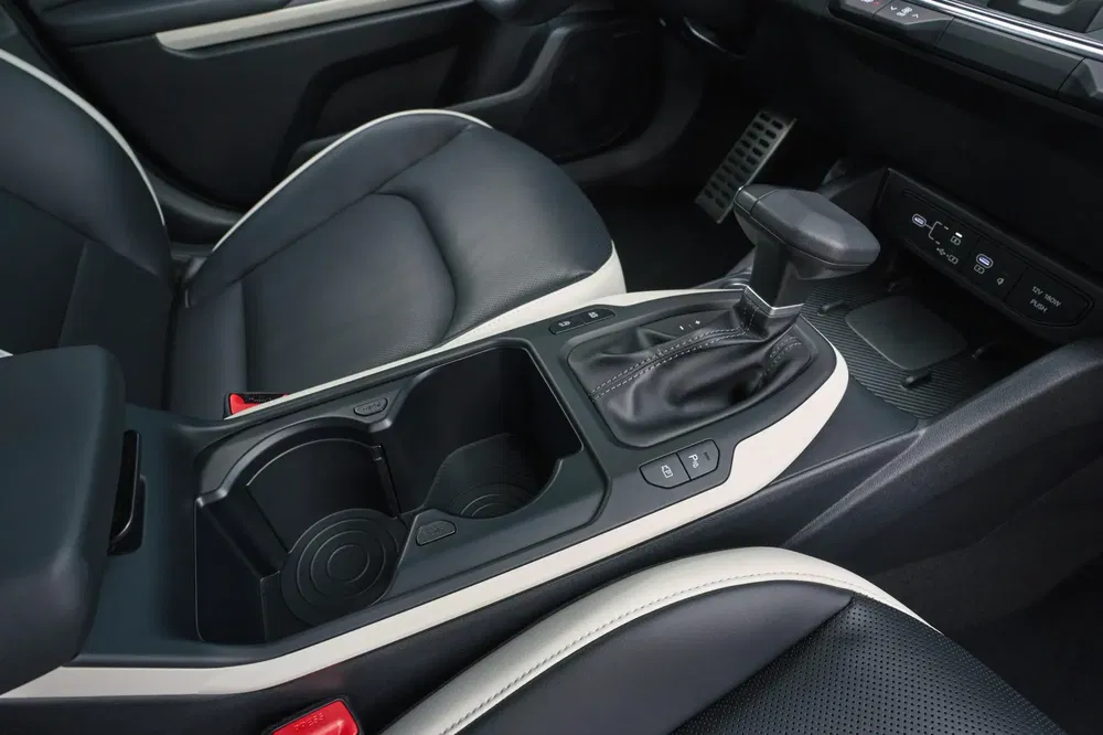 Intérieur d'une voiture moderne avec levier de vitesse et sièges en cuir noir.