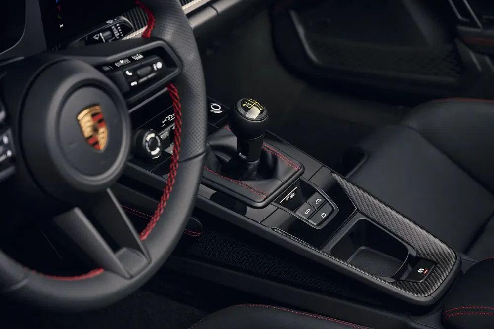 Intérieur de Porsche avec volant sport, boîte manuelle et finitions en fibre de carbone.