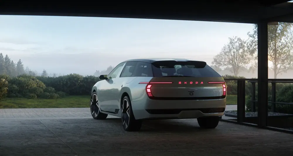 Witte Skoda elektrische auto met stijlvolle achterkant, uitzicht op tuin bij zonsopgang.