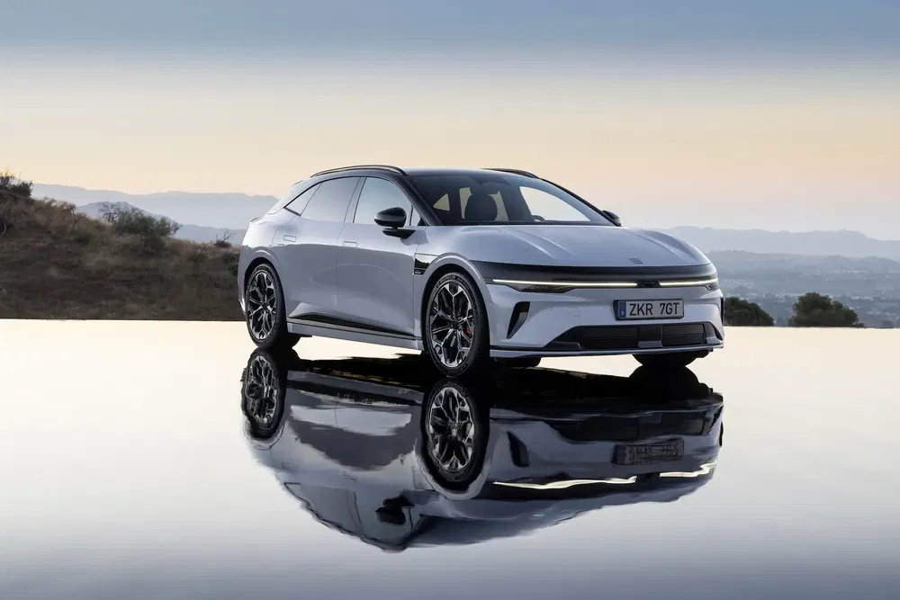 Voiture Lucid Air élégante, stationnée sur une surface réfléchissante, paysage montagneux en arrière-plan.