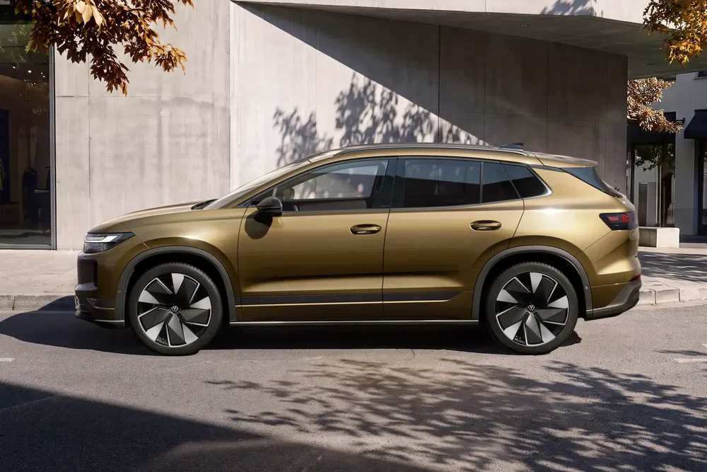 SUV Volkswagen ID.7 doré stationné en extérieur, design moderne et élégant.