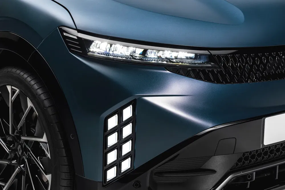 Gros plan sur l'avant d'une Renault Scénic bleu avec phares LED élégants.