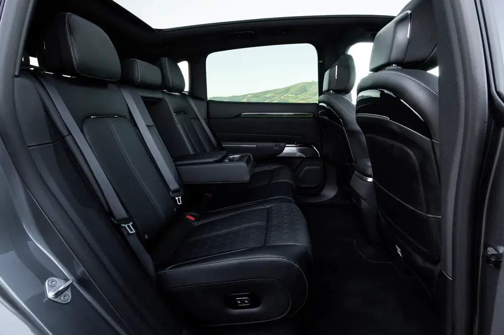 Intérieur spacieux d'un SUV moderne avec sièges en cuir noir et accoudoir central.