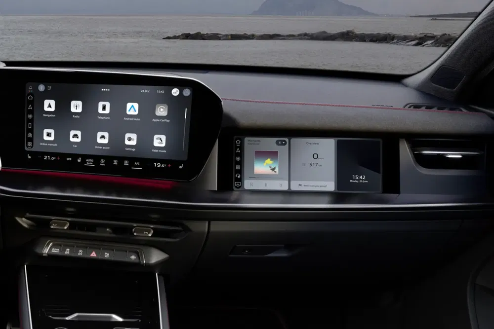 Intérieur d'une voiture Peugeot avec système d'infodivertissement moderne et vue sur l'océan.