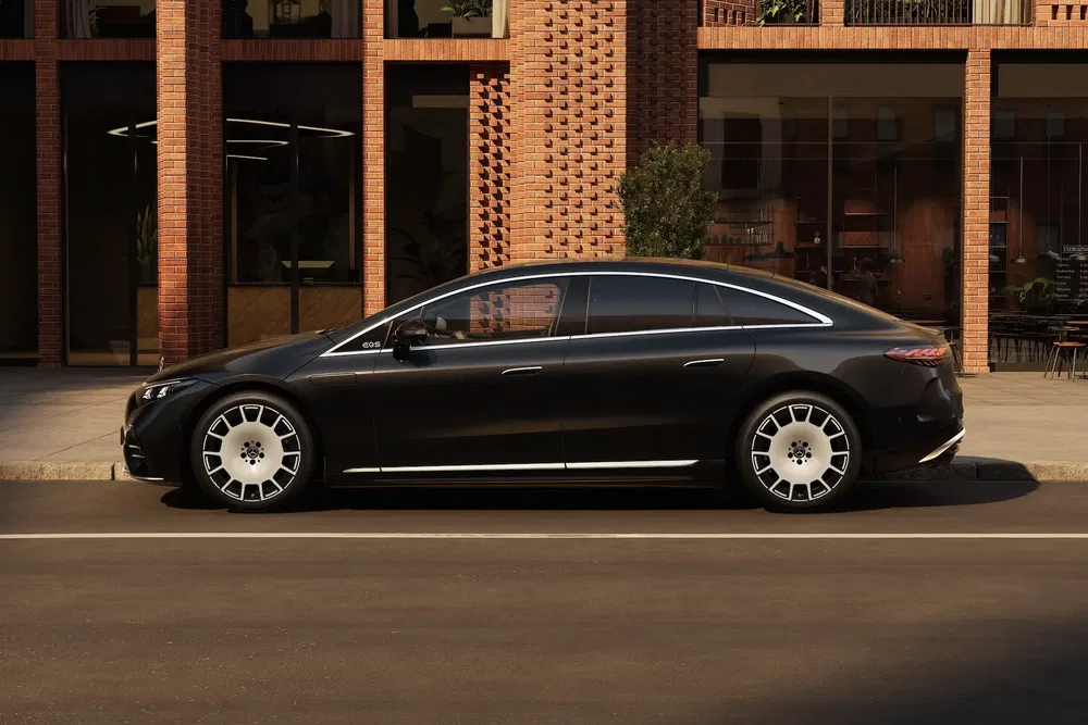 {"fr":"Mercedes-Benz EQS noire stationnée devant un bâtiment en briques rouges moderne.","nl":"Zwarte Mercedes-Benz EQS geparkeerd voor een modern rood bakstenen gebouw."}
