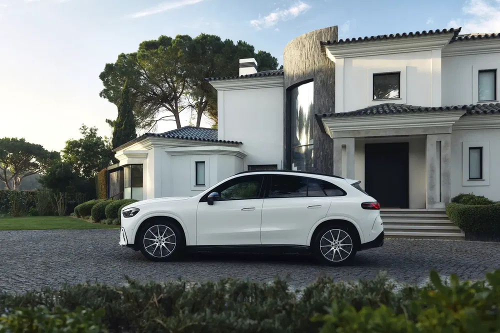Mercedes-Benz EQE SUV blanc garé devant une villa moderne.