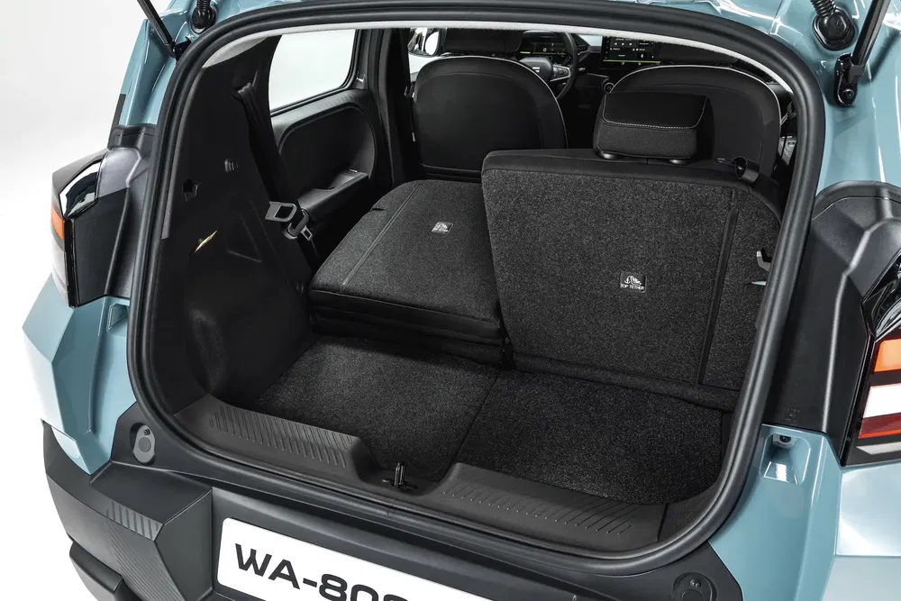 Coffre spacieux du SUV Dacia Spring avec sièges arrière rabattables et intérieur moderne.