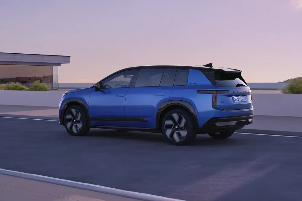 SUV Skoda bleu moderne sur autoroute au coucher du soleil, design épuré et aérodynamique.