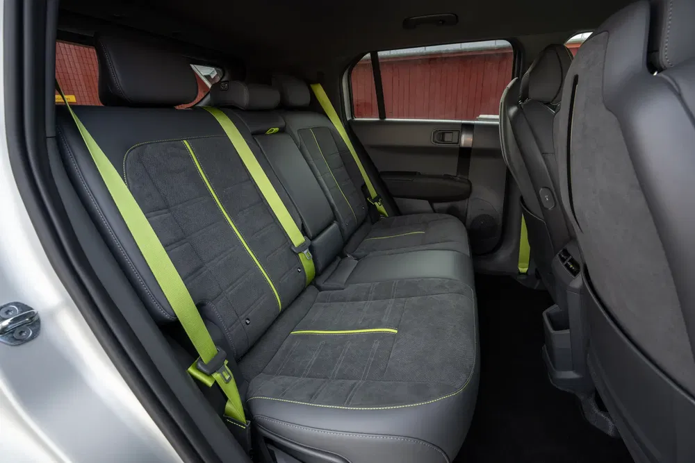 Intérieur arrière de la Jeep Avenger avec ceintures de sécurité vertes vives contrastées.