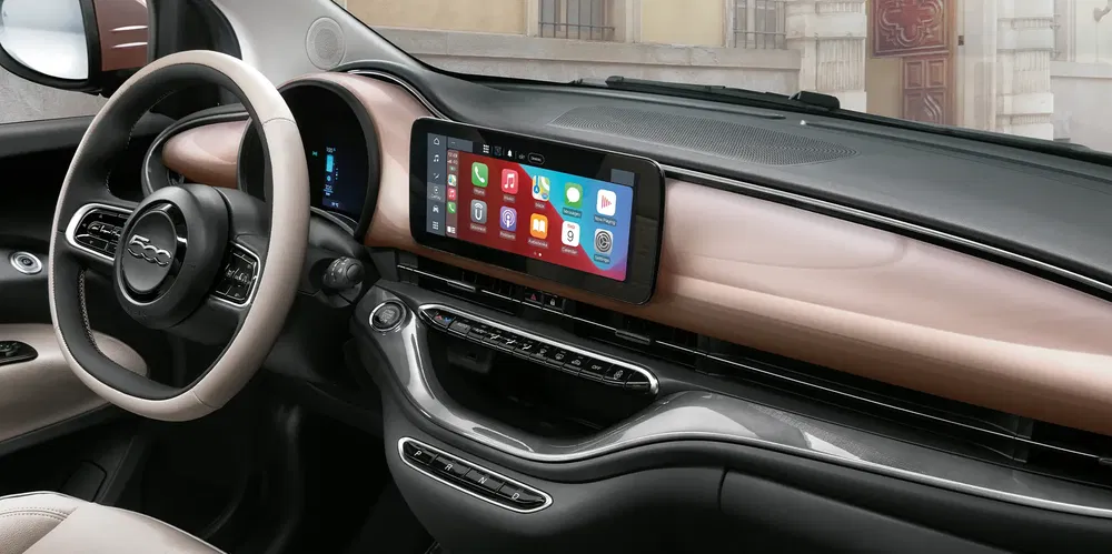 Modern interieur van de elektrische Fiat 500 met een centraal touchscreen en stijlvol stuur.