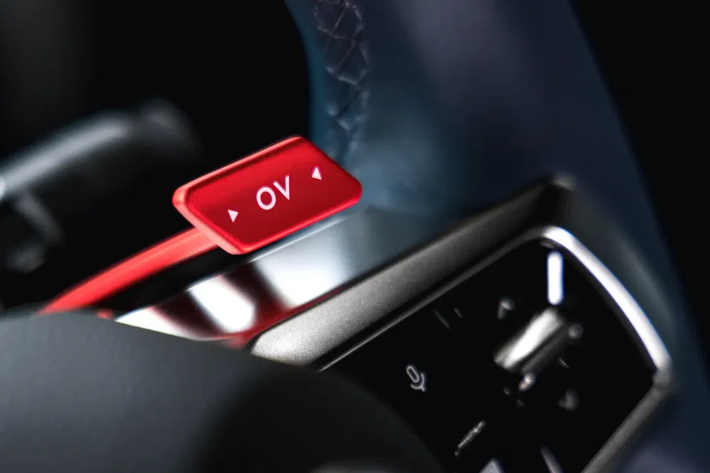 Paddle shifter rouge OV dans une voiture de sport moderne avec volant en cuir.