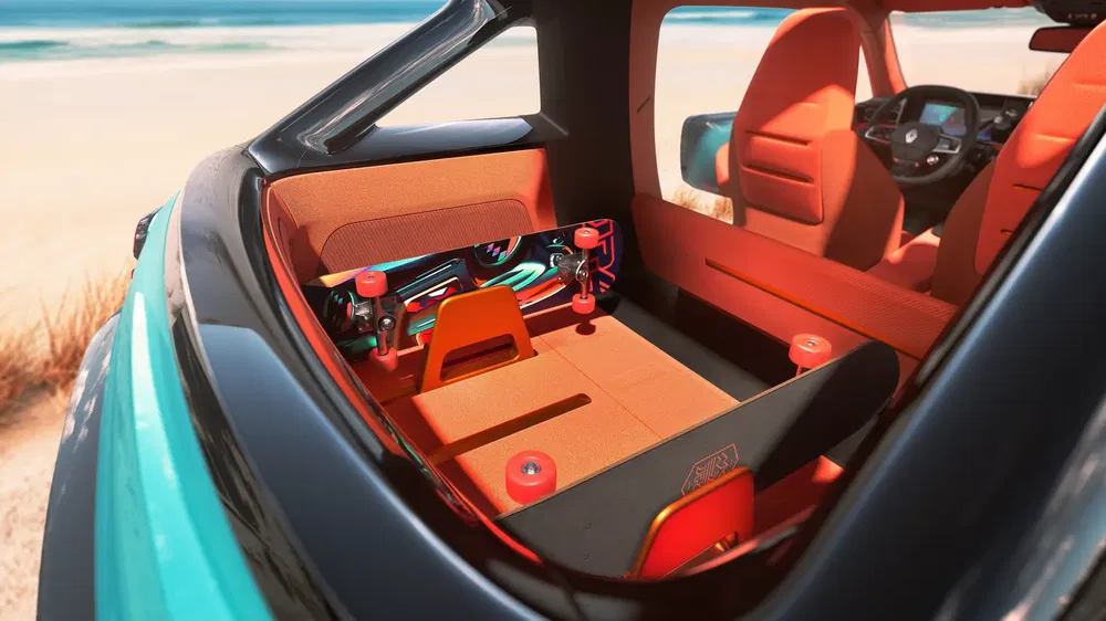 Interieur van een Volkswagen ID. Life met oranje stoelen en skateboards achterin, uitzicht op strand.