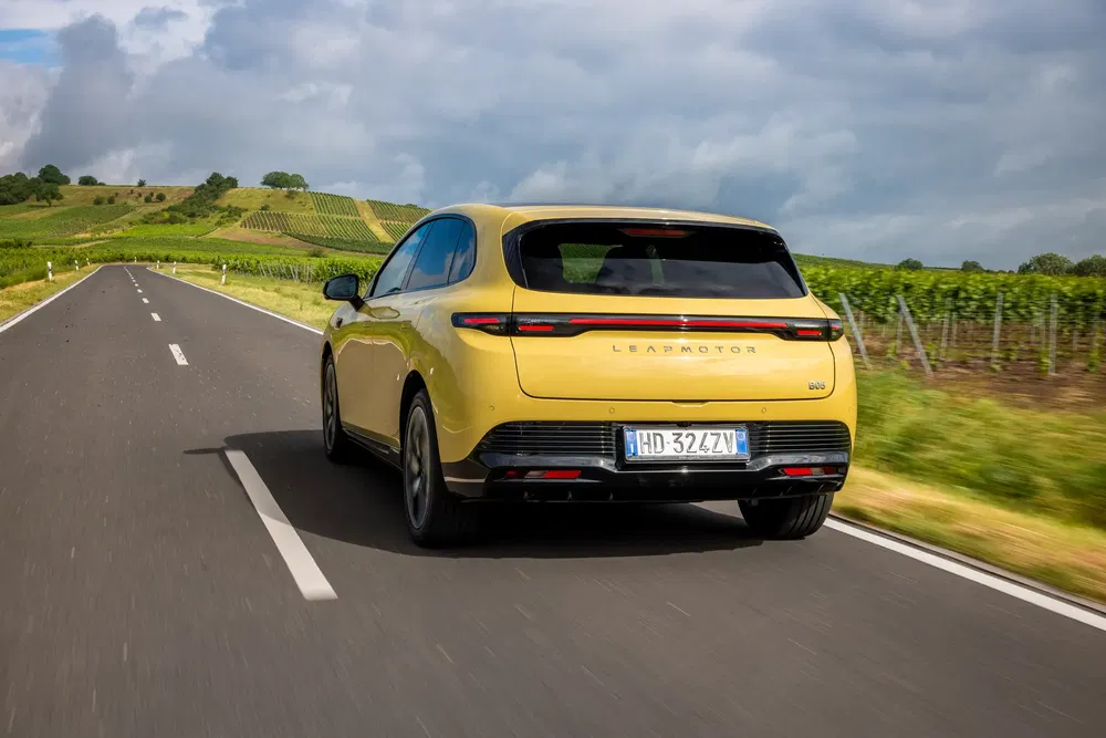 Voiture électrique Leapmotor C10 jaune roulant sur route de campagne pittoresque.