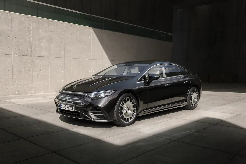 Mercedes EQS noir garée dans un espace moderne et minimaliste en plein jour.