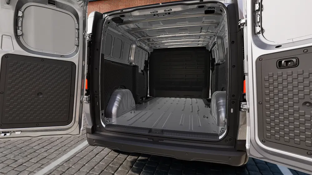 Espace cargo d'un fourgon, avec portes arrière ouvertes, idéal pour le transport de marchandises.