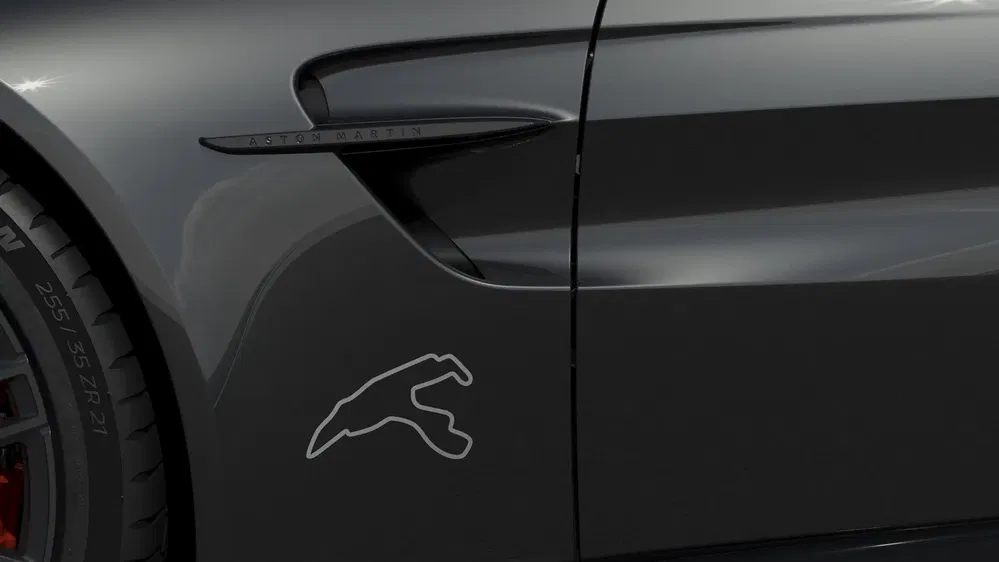 Gros plan sur une Aston Martin avec logo circuit Nürburgring sur aile avant droite.