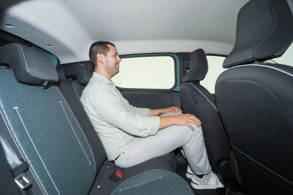Homme assis à l'arrière d'une Fiat intérieur moderne, démontrant espace pour les jambes.