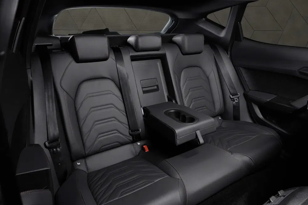 Intérieur arrière de voiture électrique moderne avec sièges en cuir noir et accoudoir central.