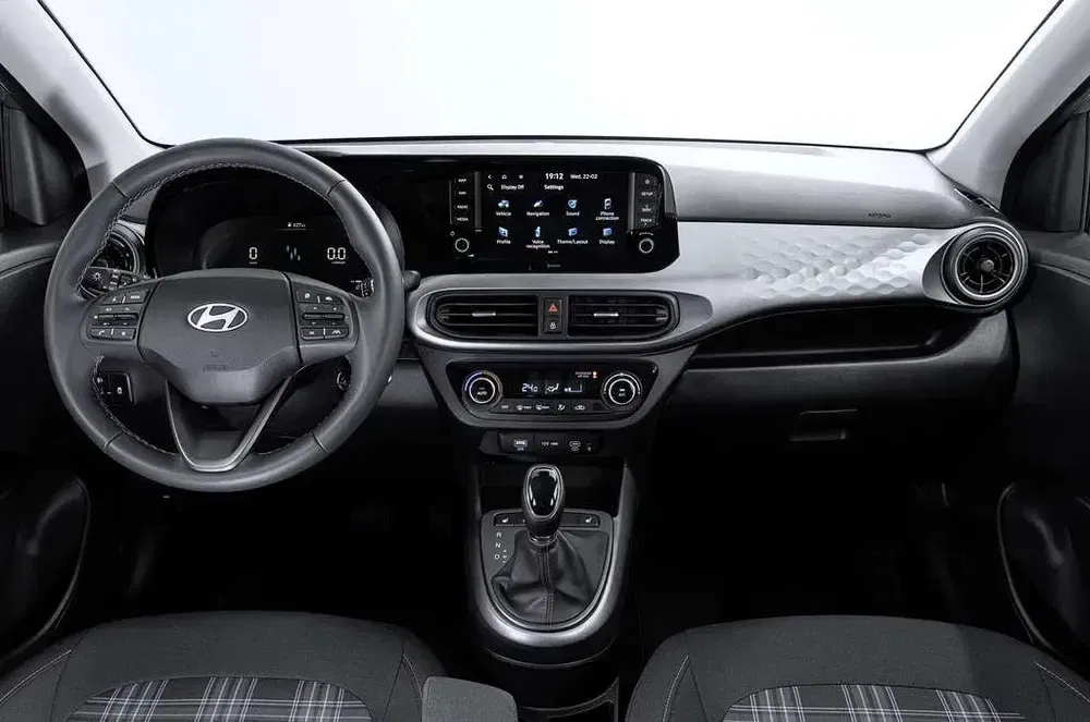 Intérieur de la Hyundai i10, tableau de bord moderne avec écran tactile et commandes intégrées.