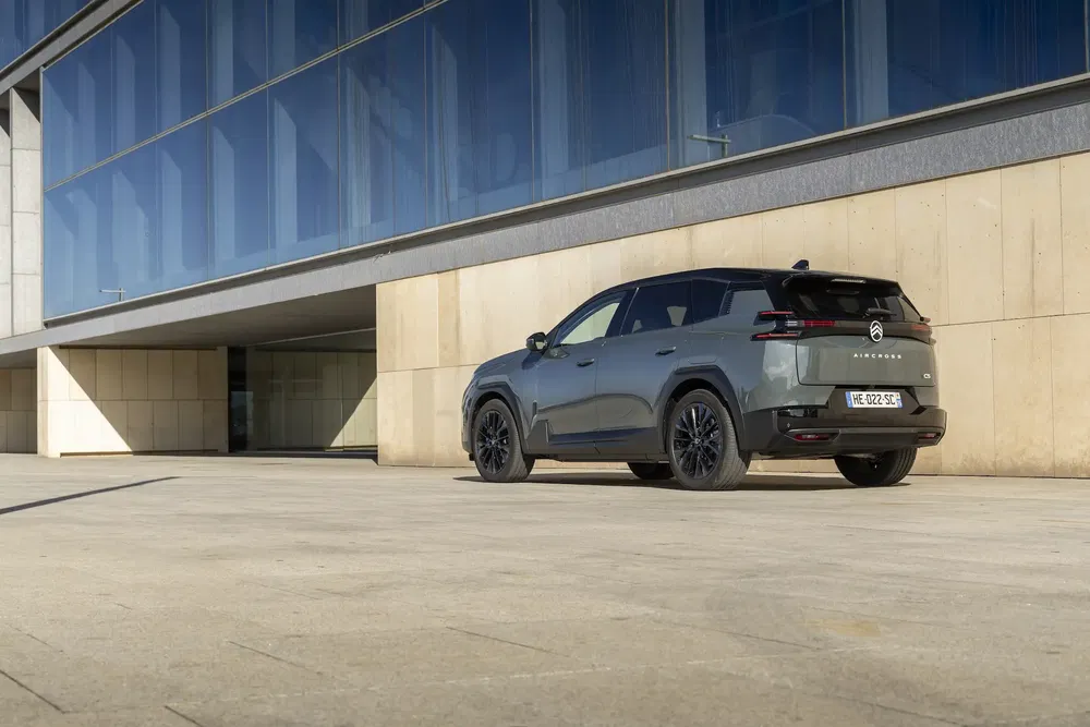 SUV Citroën C5 Aircross stationné devant un bâtiment moderne, arrière noir élégant.