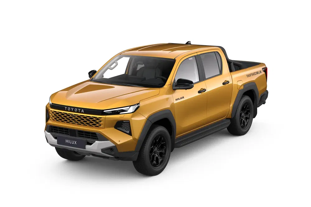 Toyota Hilux dorée, design moderne avec jantes noires et calandre élargie.