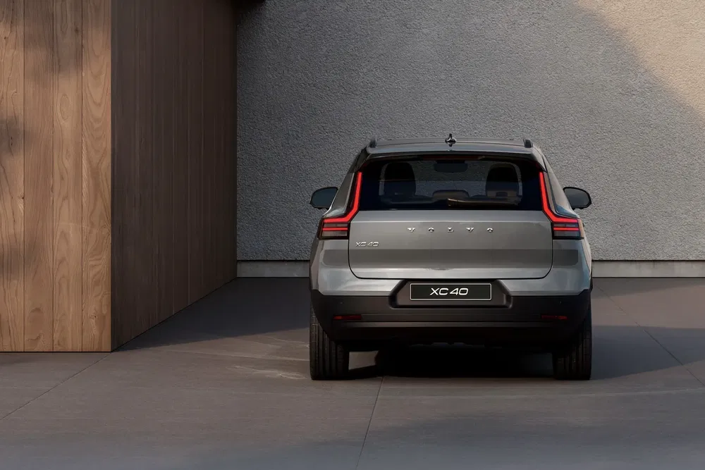 Vue arrière du Volvo XC40 moderne stationné près d'un mur texturé.
