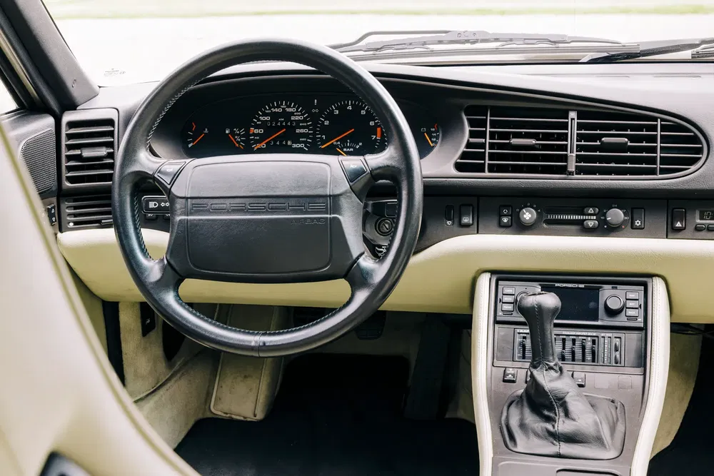 Volant et tableau de bord de la Porsche 928, intérieur classique et luxueux.