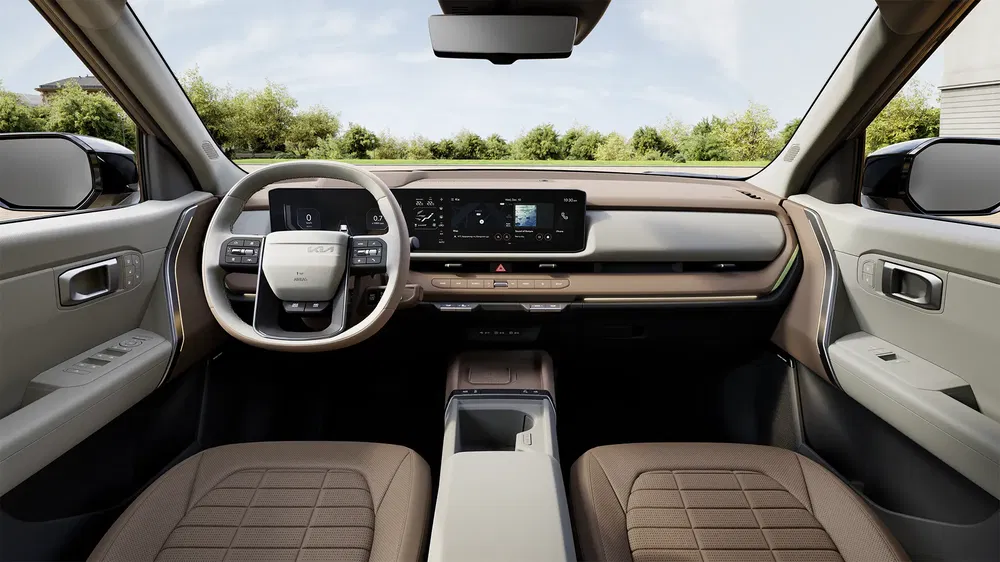 Ruim interieur van de Kia EV9 met digitaal dashboard en modern stuurwiel.